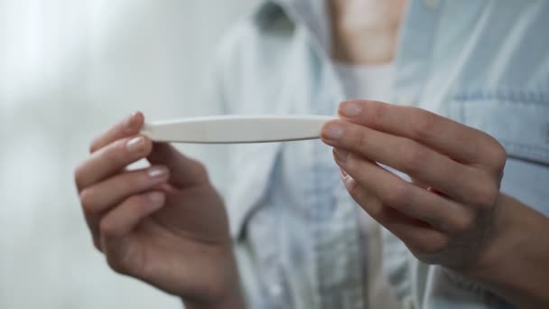 Žena se těší negativní výsledek těhotenského testu, ukazuje do kamery, detail — Stock video