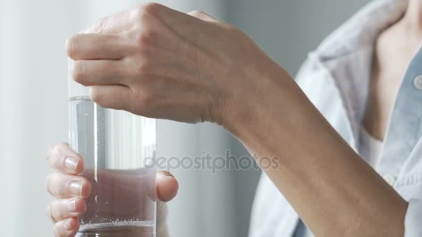 Lady poniendo aspirina en un vaso de agua, tomando analgésicos — Vídeo de stock