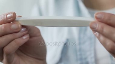 Hamilelik testi, bir satır, infertilite göstermek için dönüm tutan kadın parmakları