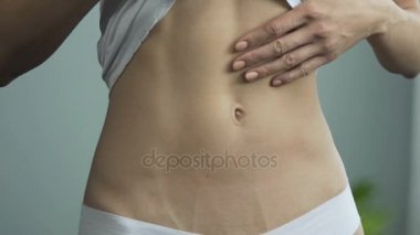 T-shirt göbek, bakmak için yukarı çekerek aynası önünde kız üzgün içinde çekerek