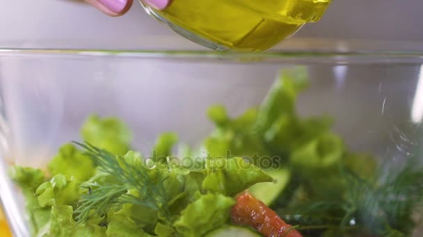 Cocinera hembra vertiendo aceite de oliva en ensalada de verduras frescas condimentándolo, lento-mo — Vídeos de Stock