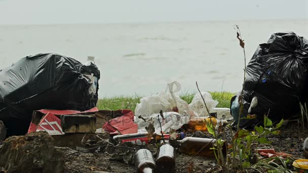 Пустые бутылки и контейнеры, загрязняющие берег моря, тонны мусора, наносящего ущерб природе — стоковое видео