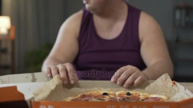 Etrafa ve geceleri, abur cubur bağımlılığı yağ pizza yiyor obez adam