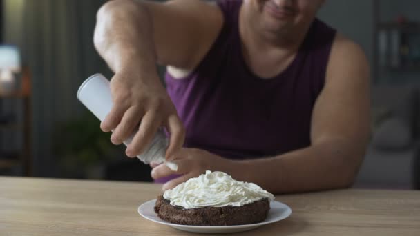 ホイップ クリーム、不健康な食品のチョコレート ケーキを飾る肥満男 — ストック動画