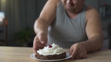 Obez kişinin kek krem şanti ile iştahla yemek ve hızlı bir şekilde, bağımlılığı