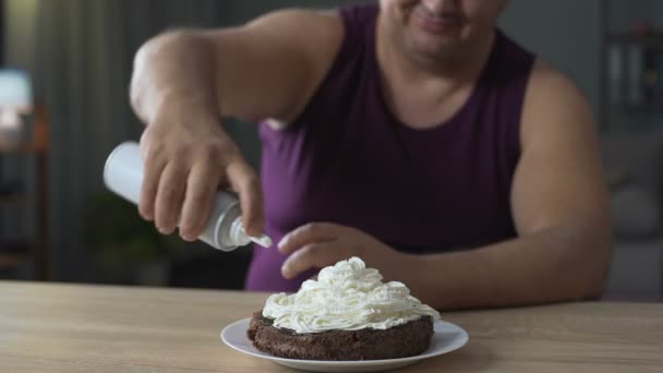 Fat Man versieren gebak met slagroom en zetten kers op de top — Stockvideo