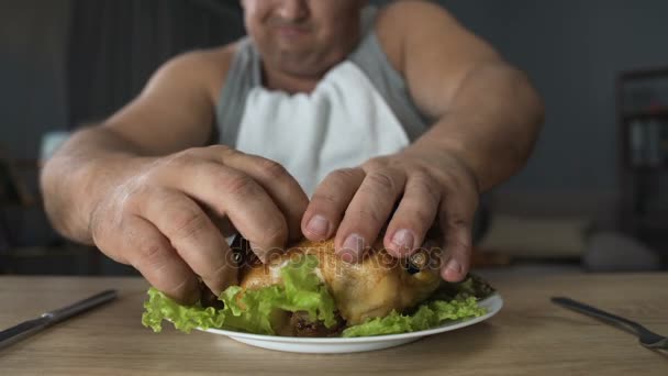 マナーの悪い男は脂ぎったフライド チキンをかむと、中毒、彼の指を舐めています。 — ストック動画