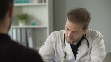 Hasta ile konuşmak ve kalp atışına stetoskop ile dinlemek erkek doktor