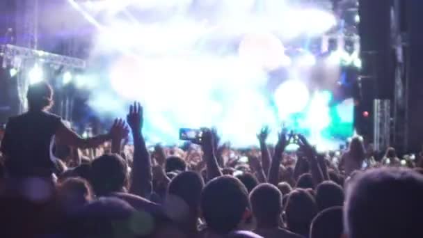 Enthusiastic crowd rejoicing and filming on mobile phones live music concert — Stock Video