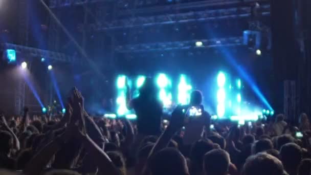 Emocionada multitud aplaudiendo activamente, saludando a los músicos en el gran escenario — Vídeos de Stock