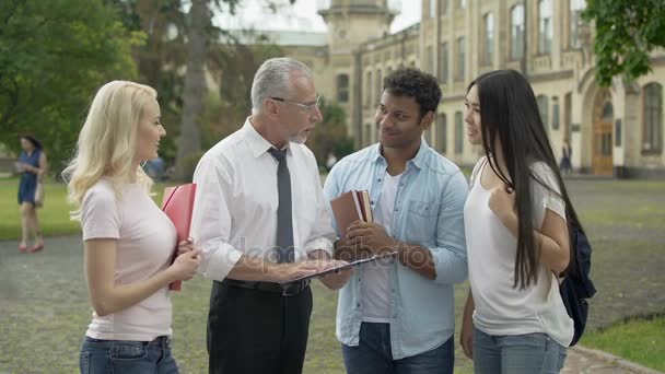 Profesor dando asignaciones a grupo de estudiantes multiétnicos, educación — Vídeo de stock