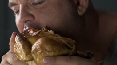 Tombul erkek ısırma kızarmış yağlı tavuk, tıkınırcasına yeme bozukluğu, sağlık sorunları