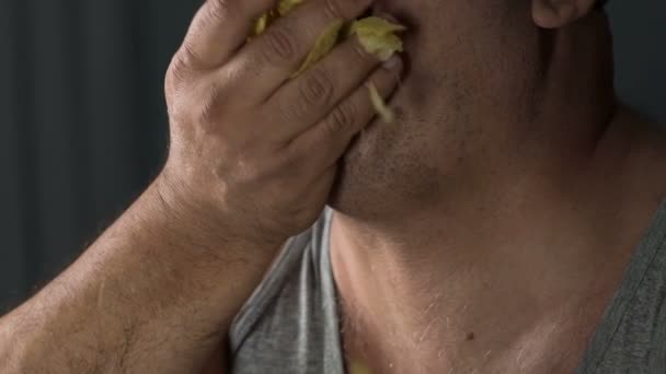 Överviktig man har snacks potatischips, överätande skräpmat, hälsoproblem — Stockvideo