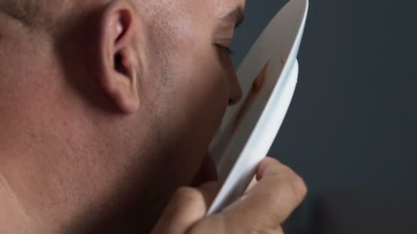 Obézní člověk jíst zbytky kečupu a mayo z desky, nevyžádané a mastné jídlo — Stock video