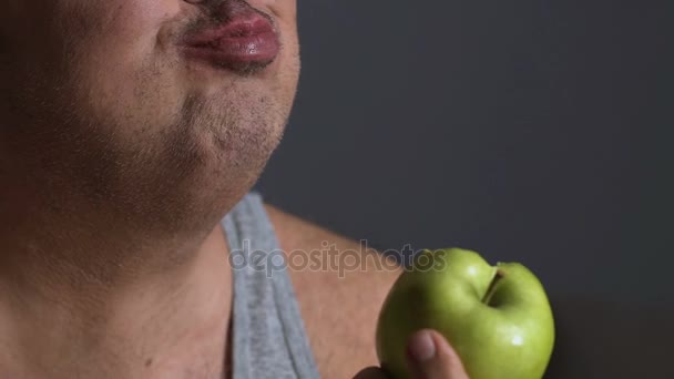 Fette Männchen kauen grünen Apfel, Ernährung und Kalorienzählung, gesunder Lebensstil