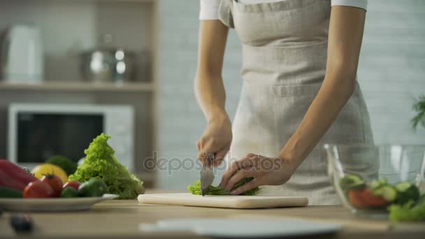 Девушка измельчает лист салата и добавляет его в стеклянную миску, здоровый образ жизни, диету — стоковое видео