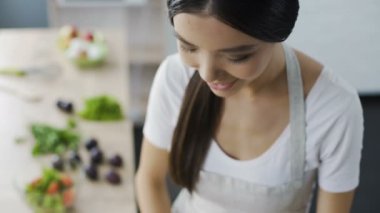 Asyalı kız bulaşık gülümseyen ve erkek hakkında düşünme Üstten Görünüm