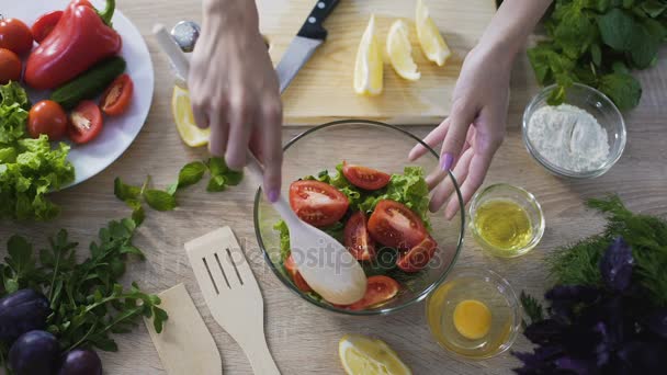 Vista superior de las manos femeninas mezclando ensalada recién cocinada y mostrándola en la cámara — Vídeos de Stock