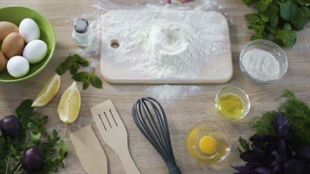 Vrouwelijke fornuis toevoegen van ei tot meel, voorbereiding van deeg voor de pannenkoeken maken — Stockvideo