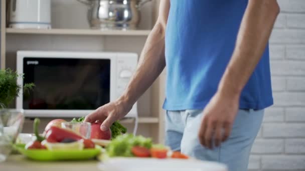 L'uomo che prende mela fresca dal tavolo, vuole avere uno spuntino sano per pranzo. — Video Stock