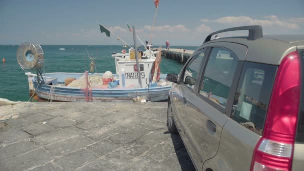 Ischia, Italien - Circa mars 2016: Transporter i staden. Visa av bil står på piren och fiske båt flyter på vatten, helg — Stockvideo