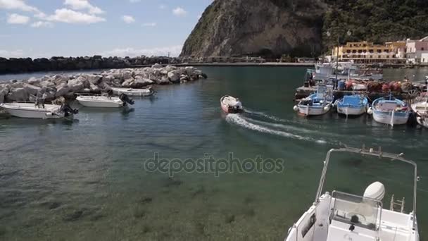 Motorbåt lämnar Sant Angelo hamn, utsikt över parkerade båtar och yachter, Italien — Stockvideo