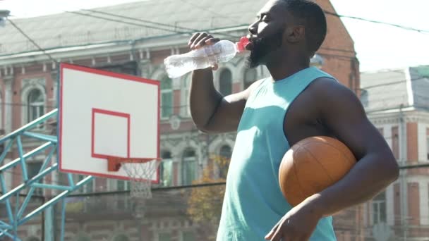 Deportista bebiendo de la botella, restaurando el equilibrio de agua después del entrenamiento activo — Vídeos de Stock