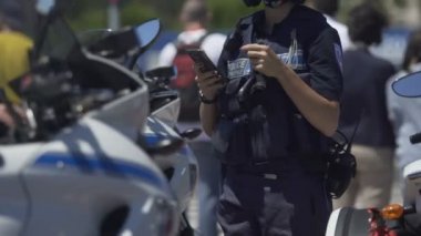 Kadın polis motosiklet yanında duran, hareket eden telefon görev kontrol memuru
