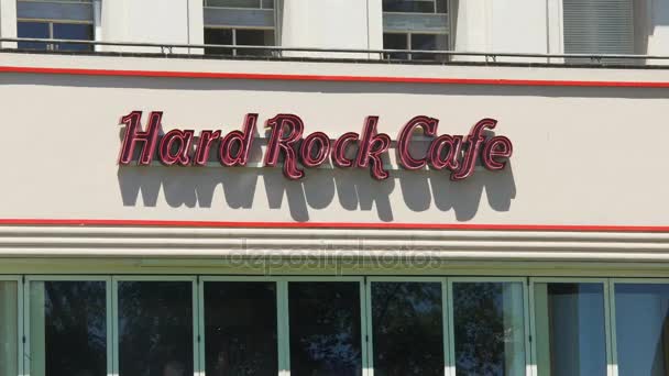 NICE, FRANCE - CIRCA JUNE 2016: Cafe in the city. Close-up of red letters saying Hard Rock Cafe, cars and buses passing in front — Stock Video