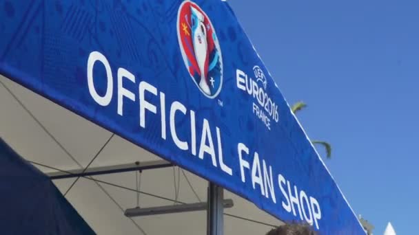 NICE, FRANCE - CIRCA JUNE 2016: Euro 2016 championship. Poster of Euro Cup Official Fan Shop hung over entrance swayed in wind, close-up — Stock Video