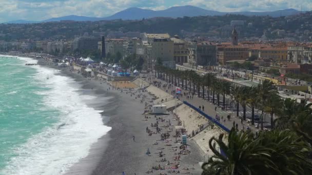 Vista de la ciudad con playa de guijarros y mar turquesa ondulando olas espumosas en la costa — Vídeo de stock