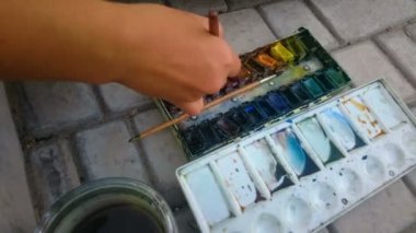 El sokak sanatçının fırça ve suluboya boyalar, yaratıcı hobi ile boyama