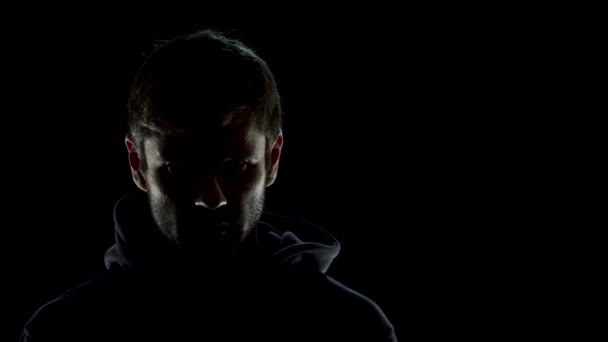 Небезпечний анонімний чоловік у нічній темряві, лякає терориста, який готується до злочину — стокове відео