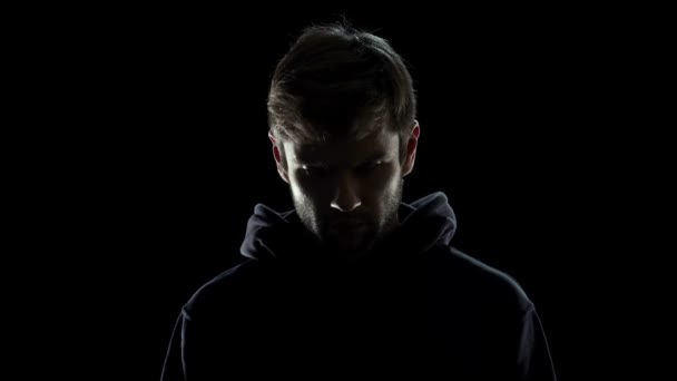 Homme méconnaissable en masque blanc regardant dans la caméra, fond de codes de données 