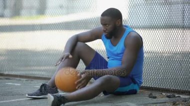 Gergin adam oturmuş tek başına çevre Stadyumu ve holding topu, kaybeden spor giyim