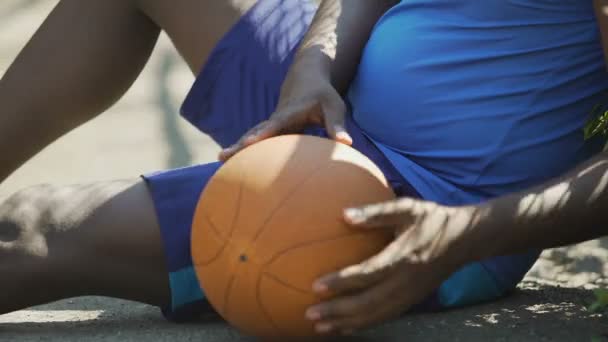 Uomo afro-americano depresso seduto a terra dopo la partita di basket — Video Stock