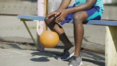 Bankta oturan binip top, üzüntü Afro-Amerikan erkek Close-Up