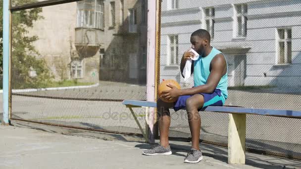 Szomorú afro-amerikai férfi ült a padon és labdáztak, magány — Stock videók