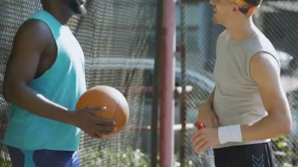 Multiracial mejores amigos de pie en el estadio y hablando de juego de baloncesto — Vídeo de stock