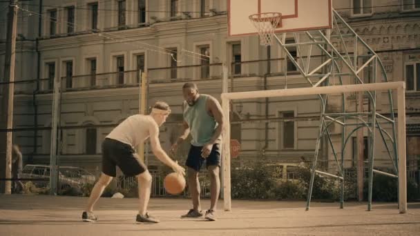 Белые и черные мужчины играют в баскетбол, активные друзья веселятся, хорошие воспоминания — стоковое видео