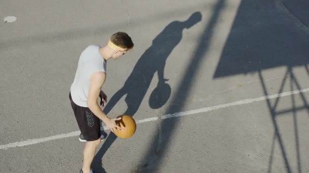 Unga kaukasiska basketspelare dribblingar en boll på stadion, sport och hobby — Stockvideo