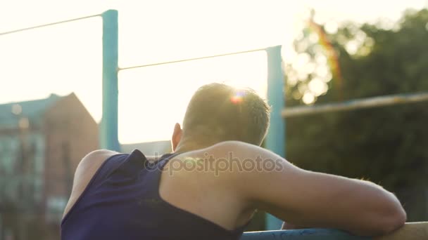 Junger Mann wärmt sich vor dem Trampolinspringen im Freien auf, aktive Freizeit, Fitness — Stockvideo