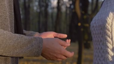 Sevgi dolu çift el ele tutuşarak sonbahar park, aşk duygularını ifade yakın çekim