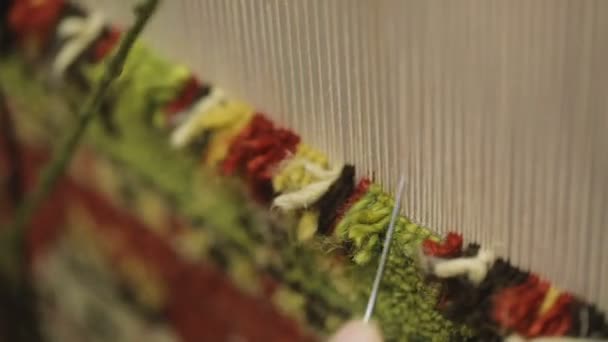 Frau webt traditionellen handgemachten Teppich aus Wolle mit speziellen Geräten — Stockvideo
