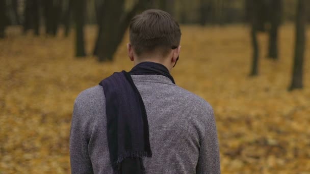 Sorgsen ung man sitta ensam i dyster höst park, känsla olycklig och ensam — Stockvideo