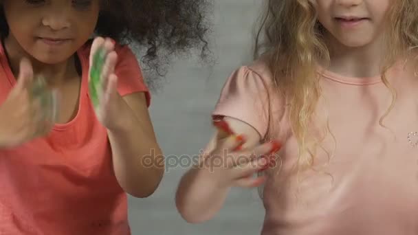 Två söta barn som täcker små händer i färgglada paint, produkten säkert för barn — Stockvideo