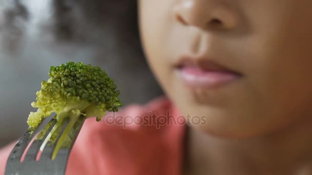 Närbild av små kid innehar färsk grön broccoli på gaffel, läckra grönsaker — Stockvideo