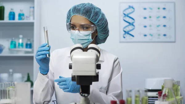 Laboratório cientista fazendo teste bacteriológico, olhando para tubo com líquido — Fotografia de Stock