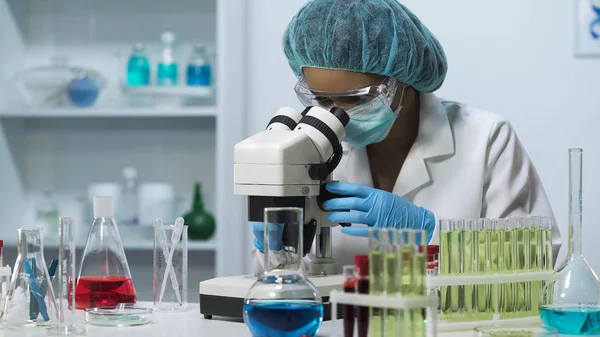 Cientista profissional do laboratório que olha no microscópio, fazendo o teste médico — Fotografia de Stock