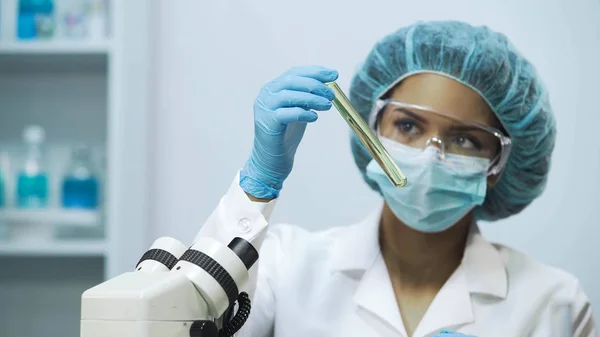 Bacteriólogo profesional que comprueba la transparencia líquida en tubo médico — Foto de Stock